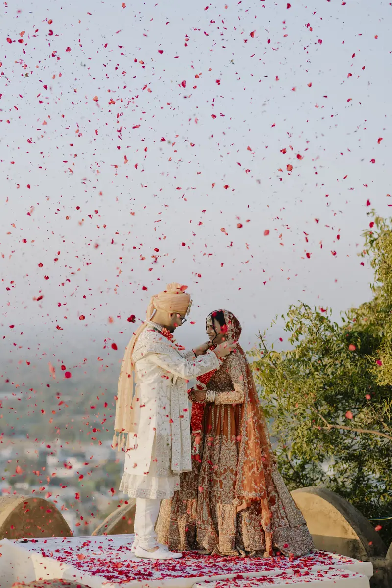 Petals thrown over a couple on a hilltop