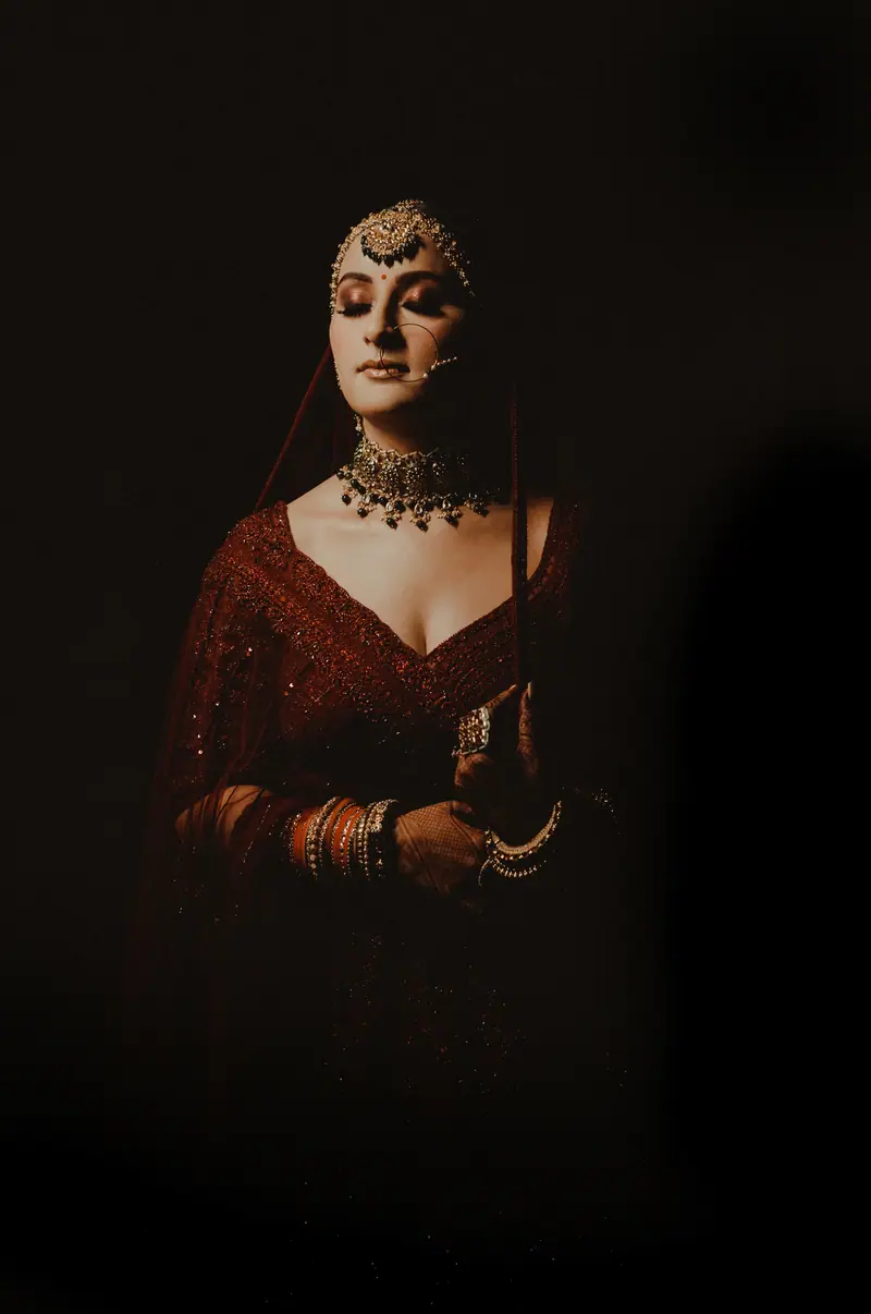 A bride in gold jewellery against near darkness